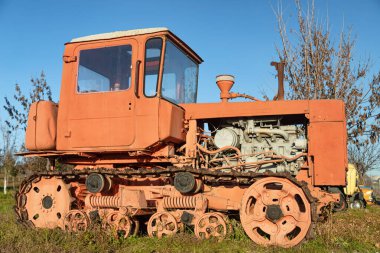 Eski bir tarla traktörü tarlada duruyor.