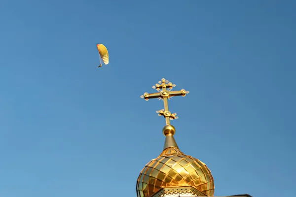 Fallskjermparaglider Flyr Den Ortodokse Kirkes Kuppel Med Gyllent Kors – stockfoto