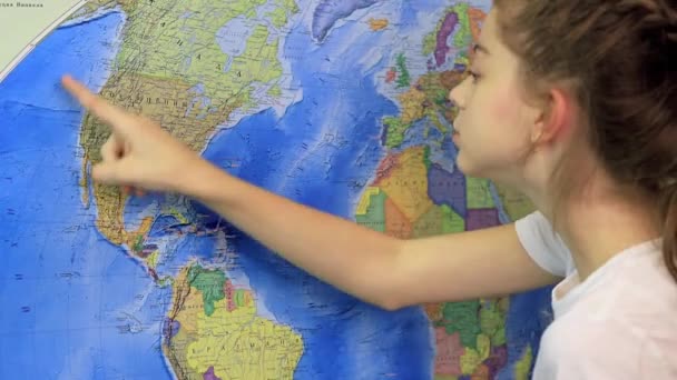 Een schoolmeisje toont de locatie van de Verenigde Staten op de wereldkaart — Stockvideo