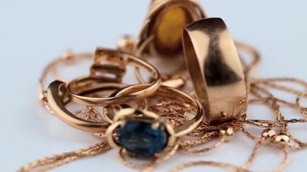 Anelli in oro con ambra, diamante e zaffiro ruotano su una parte superiore bianca — Video Stock