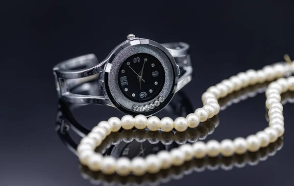 Womens watch in the original metal case and a pearl necklace — Stock Photo, Image