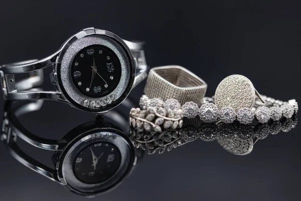Elegáns női órák fémtokban és ezüst ékszerek — Stock Fotó