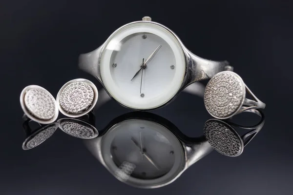 Eleganti orologi da donna in una cassa di metallo e gioielli in argento — Foto Stock