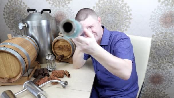Мужчина в своем блоге рассказывает об устройствах для производства виски дома — стоковое видео