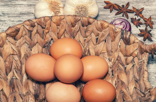 Sfondo con spezie, aglio, anice e uova di pollo in un cesto di vimini — Foto Stock