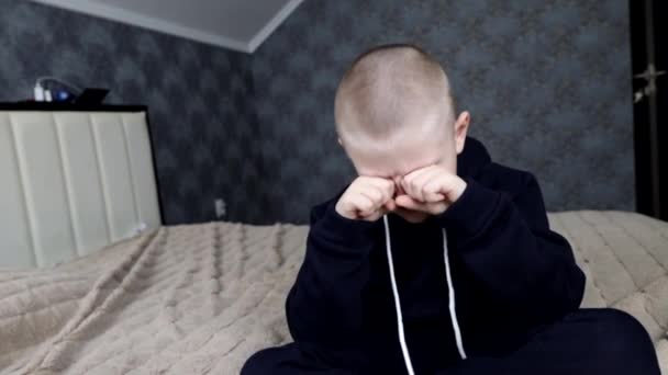 Egy óvodás fiú megdörzsöli a szemét lefekvés előtt. — Stock videók