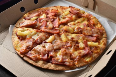 Karton bir kutuda ananas ve jambonlu pizza..