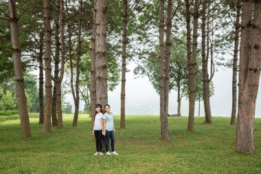  Çam ağaçlı, sisli bir anne kızı var.