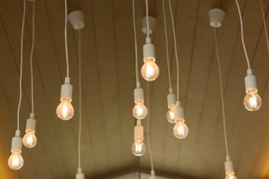 Tavandan sarkan sarı bir ampul.