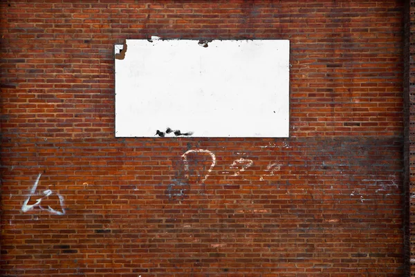 Panneau blanc vierge sur un mur de pierre — Photo