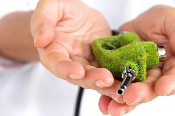 Mão segurando bico de combustível verde — Fotografia de Stock