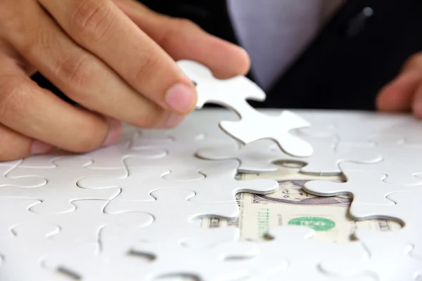 Hombre de negocios de la mano sosteniendo una pieza del rompecabezas — Foto de Stock