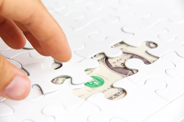 Hombre de negocios de la mano sosteniendo una pieza del rompecabezas — Foto de Stock