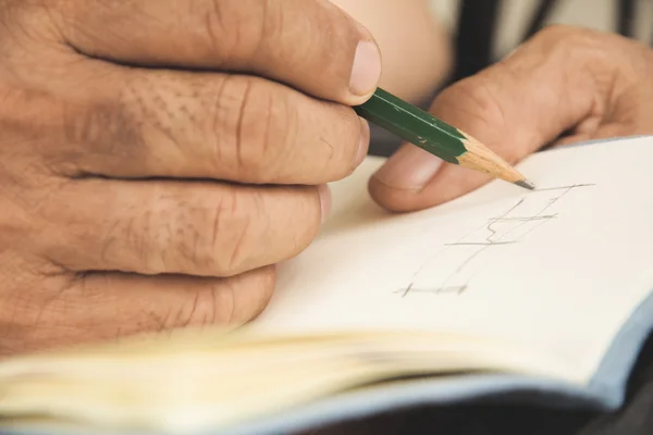 Homem escrevendo no caderno de esboços — Fotografia de Stock