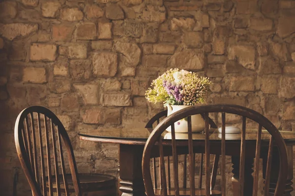 Винтажное кресло и стол с цветами — стоковое фото
