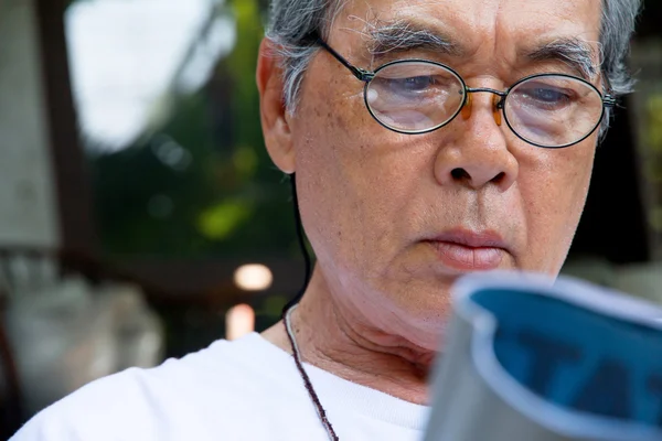 Senior homme relaxant à la maison en lisant un livre — Photo