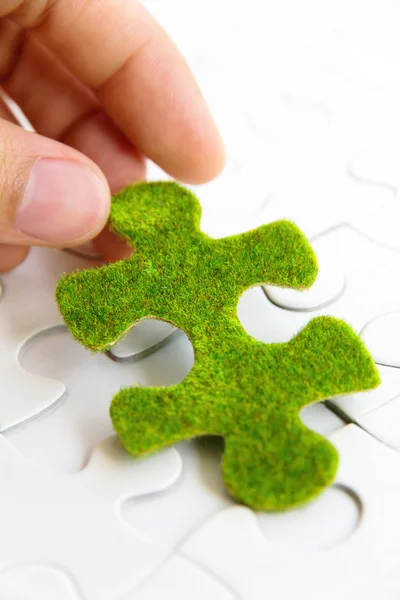 Hand hält ein grünes Puzzleteil — Stockfoto