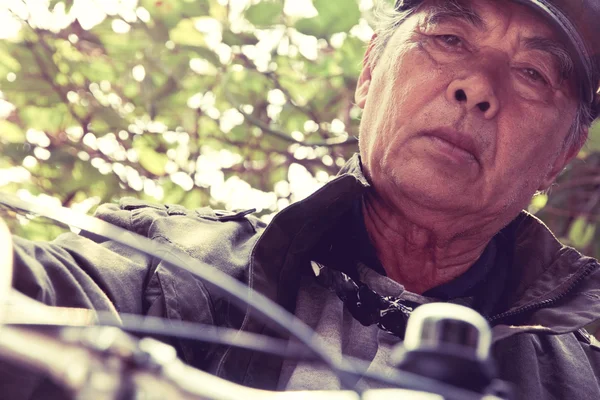 Senior asiático hombre cabalgando su bicicleta — Foto de Stock