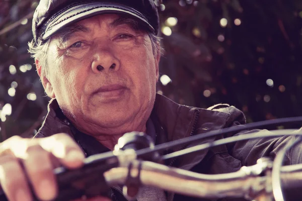 Senior asiatischer Mann auf seinem Fahrrad — Stockfoto