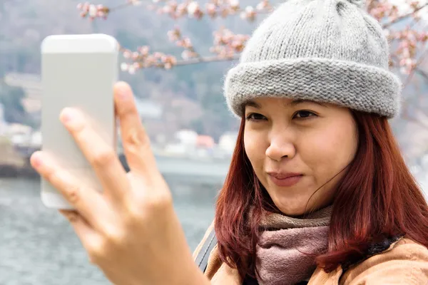 Jonge Aziatische vrouwen kijken naar haar mobiele telefoon — Stockfoto