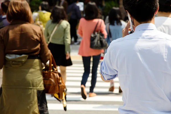 Touristes et hommes d'affaires traversant la rue — Photo