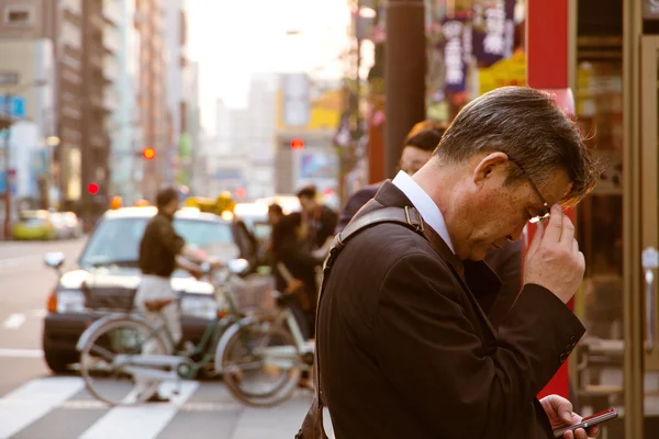 Podnikatel kontroluje svůj mobilní telefon — Stock fotografie