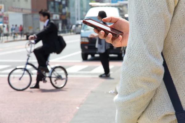 Japanse man maakt gebruik van tekstchat op de telefoon — Stockfoto