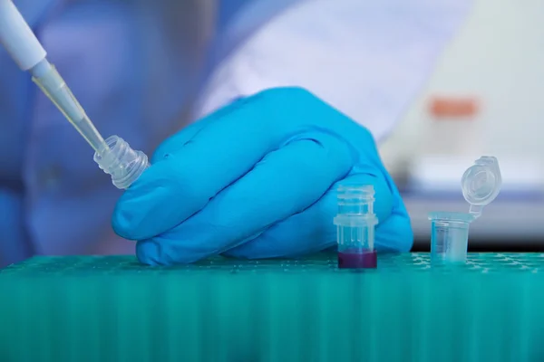 Pipette with drop of liquid in a science research lab — Stock Photo, Image