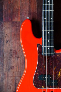 Tahta zemin üzerinde kopyalama alanı olan turuncu elektro gitar