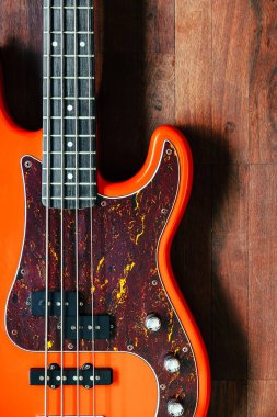 Tahta zemin üzerinde kopyalama alanı olan turuncu elektro gitar