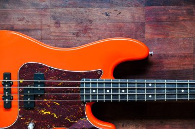 Tahta zemin üzerinde kopyalama alanı olan turuncu elektro gitar