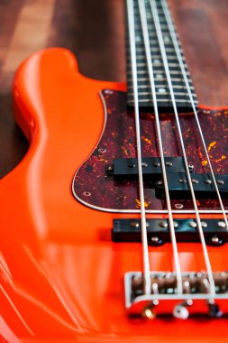 Tahta zemin üzerinde kopyalama alanı olan turuncu elektro gitar