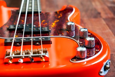 Tahta zemin üzerinde kopyalama alanı olan turuncu elektro gitar