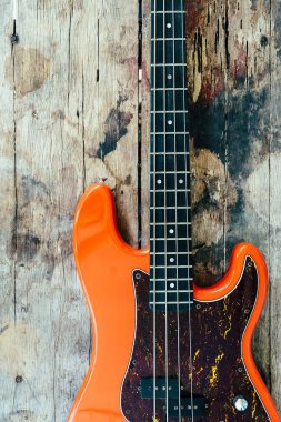 Tahta zemin üzerinde kopyalama alanı olan turuncu elektro gitar