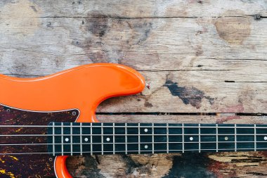 Tahta zemin üzerinde kopyalama alanı olan turuncu elektro gitar