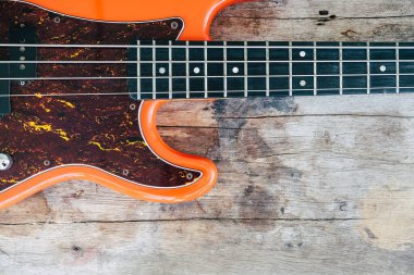 Tahta zemin üzerinde kopyalama alanı olan turuncu elektro gitar