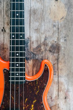 Tahta zemin üzerinde kopyalama alanı olan turuncu elektro gitar