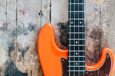 Tahta zemin üzerinde kopyalama alanı olan turuncu elektro gitar