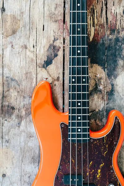 Tahta zemin üzerinde kopyalama alanı olan turuncu elektro gitar