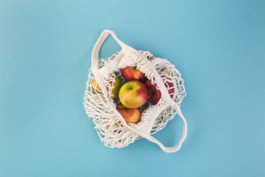 Kırmızı elma ve ip torbası mavi bir masada. Yaz ya da sonbahar sezonu. Çevre alışveriş kavramı