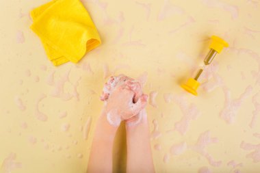 El yıkama konsepti. Evde el yıkama. Coronavirus konsepti. Çocuk elleri sarı köpüklü