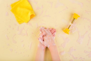 El yıkama konsepti. Evde el yıkama. Coronavirus konsepti. Çocuk elleri sarı köpüklü