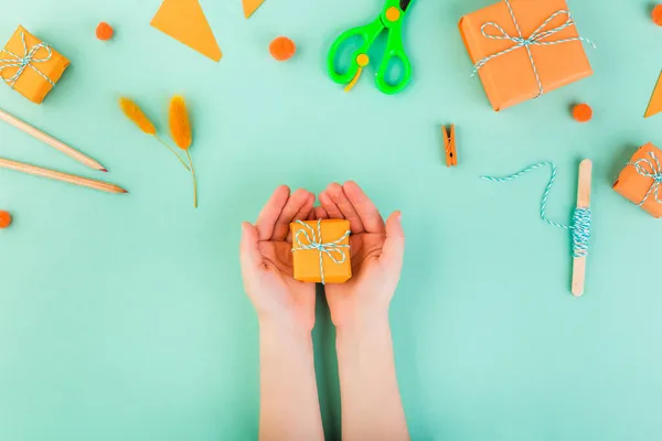 Concetto regalo con mano giovane dando scatola regalo arancione fatto a mano — Foto Stock