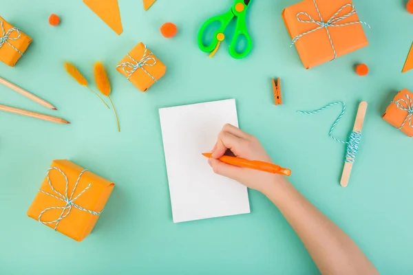 Kind Hand weiß eine Festkarte Geschenk geben Konzept orange Stil — Stockfoto