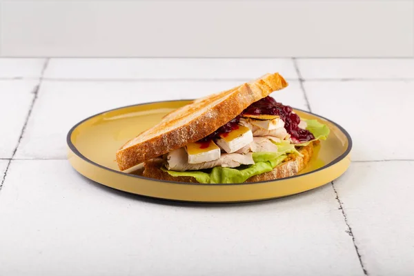 Sandwich au fromage Bri salade de poulet et confiture sur assiette jaune — Photo