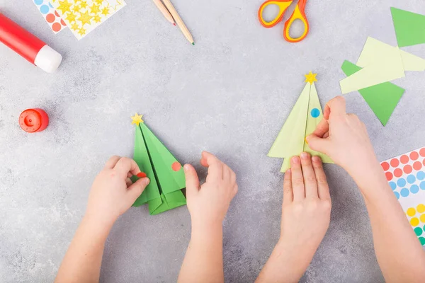 I bambini decorano origami di albero di carta. Collage di carta natalizia. Realizzato con le sue mani. Progetto artistico per bambini artigianale per bambini. Artigianato per bambini. Vista dall'alto — Foto Stock