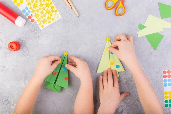 Çocuklar kağıt ağacı origamisini süsler. Noel kâğıdı kolajı. Kendi elleriyle yapmış. Çocuklar için sanat projeleri. Çocuklar için el işi. Üst görünüm — Stok fotoğraf