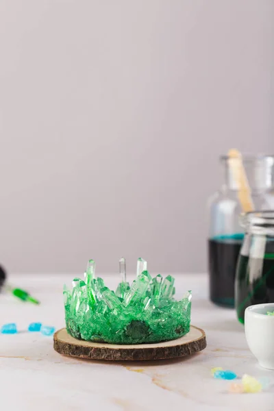 Zelený krystal vypěstovaný dítětem. Věda je zábavný koncept. Experiment s dětmi doma — Stock fotografie
