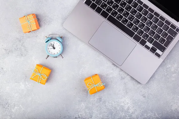 Laptop i pomarańczowe prezenty na niebieskim stole płaskie układanki. Wakacyjna koncepcja zakupów online. — Zdjęcie stockowe