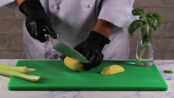 Eine Köchin schneidet Kartoffeln mit Messer in Scheiben. — Stockvideo